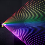 Unity Raw 5 RGB laser projector casting a wide fan of rainbow beams through haze